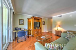 a living room with a couch and a tv at Marco Island Condo with Patio Steps to Beach Access in Marco Island