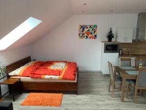 a bedroom with a bed and a table and a kitchen at Apartmán Liso in Bobrovec