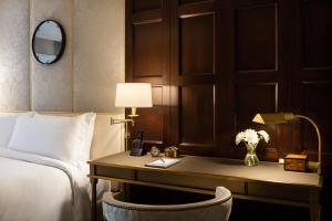 a hotel room with a bed and a desk with a lamp at Rosewood Mansion on Turtle Creek in Dallas