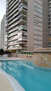 a large swimming pool in front of a tall building at Amazing Oceanfront unit on Mansa Beach in Punta del Este