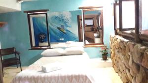 a bedroom with two beds and a painting on the wall at Casa das Palmeiras Pé na Areia in Ubatuba