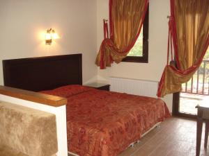 a bedroom with a bed and a window at Village Naiades in Kastoria