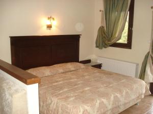 a bedroom with a bed and a window at Village Naiades in Kastoria +8 photos