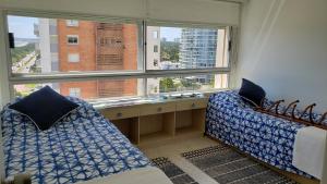 a room with two beds and a large window at Amazing Oceanfront unit on Mansa Beach in Punta del Este +15 photos