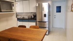 a kitchen with a wooden table and a refrigerator at Amazing Oceanfront unit on Mansa Beach in Punta del Este