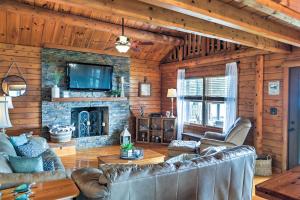 a living room with leather furniture and a stone fireplace at Lake Broward Cabin with Private Boat Launch and Dock! in Satsuma