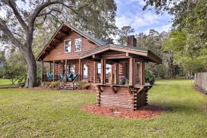 a small log cabin in a yard with a tree at Lake Broward Cabin with Private Boat Launch and Dock! in Satsuma