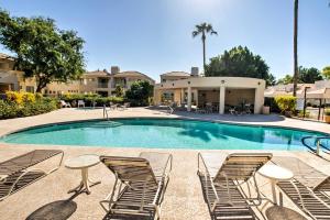 a swimming pool with lounge chairs and a table at Sleek Scottsdale Condo Balcony and Resort Amenities in Scottsdale