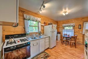 a kitchen with a white refrigerator and a table at Cozy Colorado Cabin with Deck, Grill and River Access! in Buena Vista