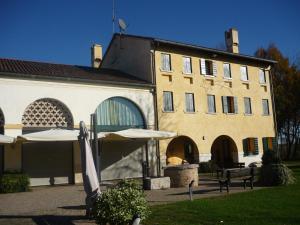 un gran edificio con sombrillas delante en Le Vigne Morosina, en Cessalto
