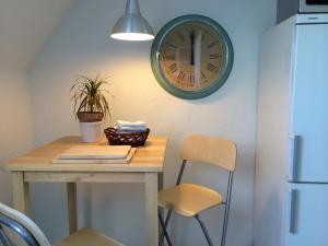 une table et des chaises avec une horloge sur le mur dans l'établissement Guesthouse Copenhagen Beach, à Copenhague