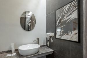 a bathroom with a white sink and a mirror at Bunk & Bilik Hotel Sri Petaling in Kuala Lumpur