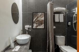 a bathroom with a sink and a toilet and a mirror at Bunk & Bilik Hotel Sri Petaling in Kuala Lumpur