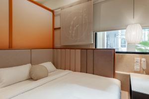 a small bedroom with a bed with a mirror at Bunk & Bilik Hotel Sri Petaling in Kuala Lumpur