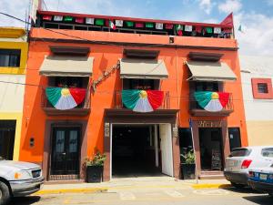 un edificio naranja con sombrillas en las ventanas en Hotel Jiménez en Oaxaca de Juárez