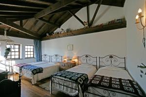 a bedroom with two beds and a wooden ceiling at Casa de Darei in Mangualde