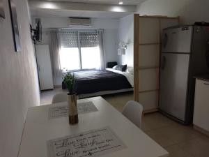 a room with a table and a kitchen with a bed at Apart Zeta in Belén de Escobar