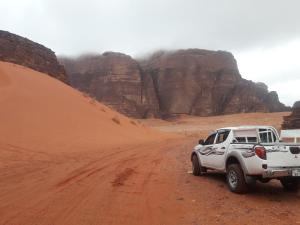 un camión blanco estacionado en un camino de tierra en el desierto en WadiRum Mobile Camp, en Wadi Rum