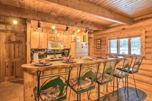 Cabaña de madera con cocina con una gran isla con taburetes en Cozy Glacier Park Log Cabin - Best in the West! en Essex