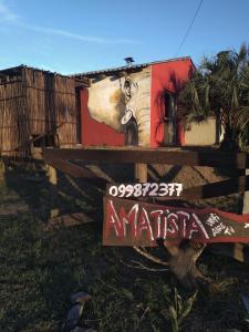 una señal frente a un edificio con una pintura en Amatista, en Punta del Diablo