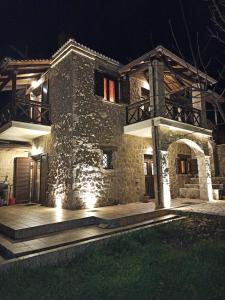 kamienny dom w nocy ze światłami w obiekcie AELIA HOME w mieście Synikia Mesi Trikalon