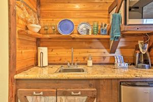 uma cozinha com um lavatório num chalé de madeira em Gruene Cabin - Pet Friendly New Braunfels Studio em New Braunfels