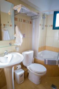 a bathroom with a toilet and a sink and a tub at Mariamare apts in Stalís