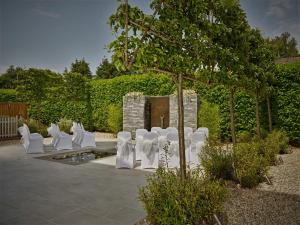 a row of white chairs in a garden at Cotswold Grange in Cheltenham