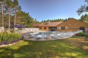 a yard with chairs and a pool in front of a house at Resort-Style Harbor Springs Home with Deck! in Harbor Springs