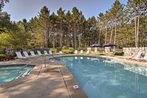 a swimming pool with lounge chairs at Resort-Style Harbor Springs Home with Deck! in Harbor Springs