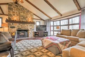 een woonkamer met een stenen open haard en een bank bij Macungie Cabin with Fireplace Near Bear Creek Skiing in Macungie