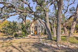 una casa en el bosque con árboles en Cozy Texas Retreat with Patio, Grill and Fire Pit!, en Mountain Home