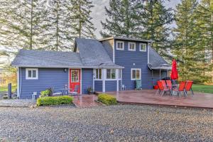 Una casa azul con sillas rojas y una terraza. en Peacock Hill Retreat on 1 Acre, 1 Mi to Harbor, en Gig Harbor