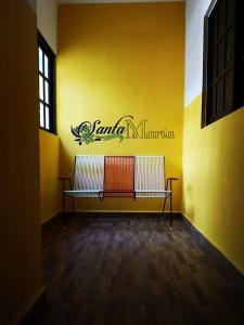a yellow wall with a bench in a room at Hotel Santa María Homun in Homún