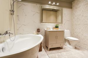a bathroom with a tub and a toilet and a sink at Old town Kalku Apartment in Rīga +13 photos