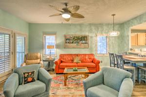 a living room with an orange couch and chairs at Resort Condo with Porch 1 Mi to North Myrtle Beach! in North Myrtle Beach