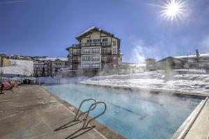 格蘭比的住宿－Base Camp One Resort Escape Steps From Ski Lifts!，一座积雪游泳池和一座建筑的背景