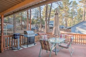 a screened porch with a grill and a table and chairs at Ruidoso Lil Mountain Getaway - Links Golf Course in Ruidoso