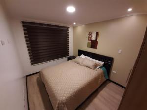 A bed or beds in a room at Condominio La Victoria, Departamento en Cuenca 1