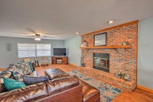 a living room with a couch and a brick fireplace at Gorgeous Waldo Home with Dock on Santa Fe Lake! in Waldo