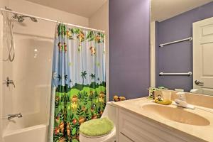 a bathroom with a shower curtain with a toilet and a sink at Stunning Duluth Family House with Fireplace and Patio! in Duluth +32 photos