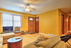 a living room with yellow walls and a ceiling fan at Wooded Twin Lakes Retreat 13 Mi to Lake Michigan! in Twin Lake