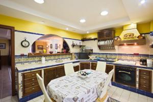 cocina con mesa y cocina con paredes amarillas en Casa Marta, en Tajarja