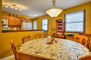 a kitchen and dining room with a table and chairs at Wooded Twin Lakes Retreat 13 Mi to Lake Michigan! in Twin Lake