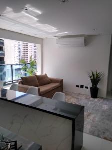 sala de estar con sofá y mesa en Flat top Guarujá, en Guarujá