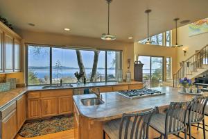 Casa dAmore Extravagant Lakefront Villa! في Granite Bay: مطبخ مع نافذة كبيرة وكاونتر مع الكراسي