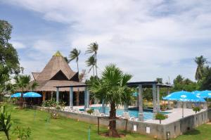 una piscina del resort con sedie e ombrelloni di Samui Honey Suite a Choeng Mon Beach