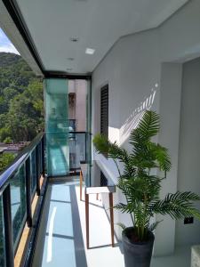 een balkon met een stoel en een plant bij Flat top Guarujá in Guarujá