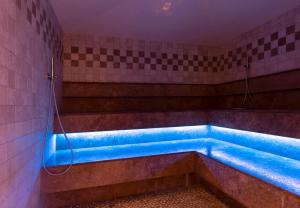 Habitación con baño con bañera azul. en Hotel Melchiori, en Andalo