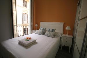 a bedroom with a white bed and white walls at Apartamentos Calle Larios in Málaga